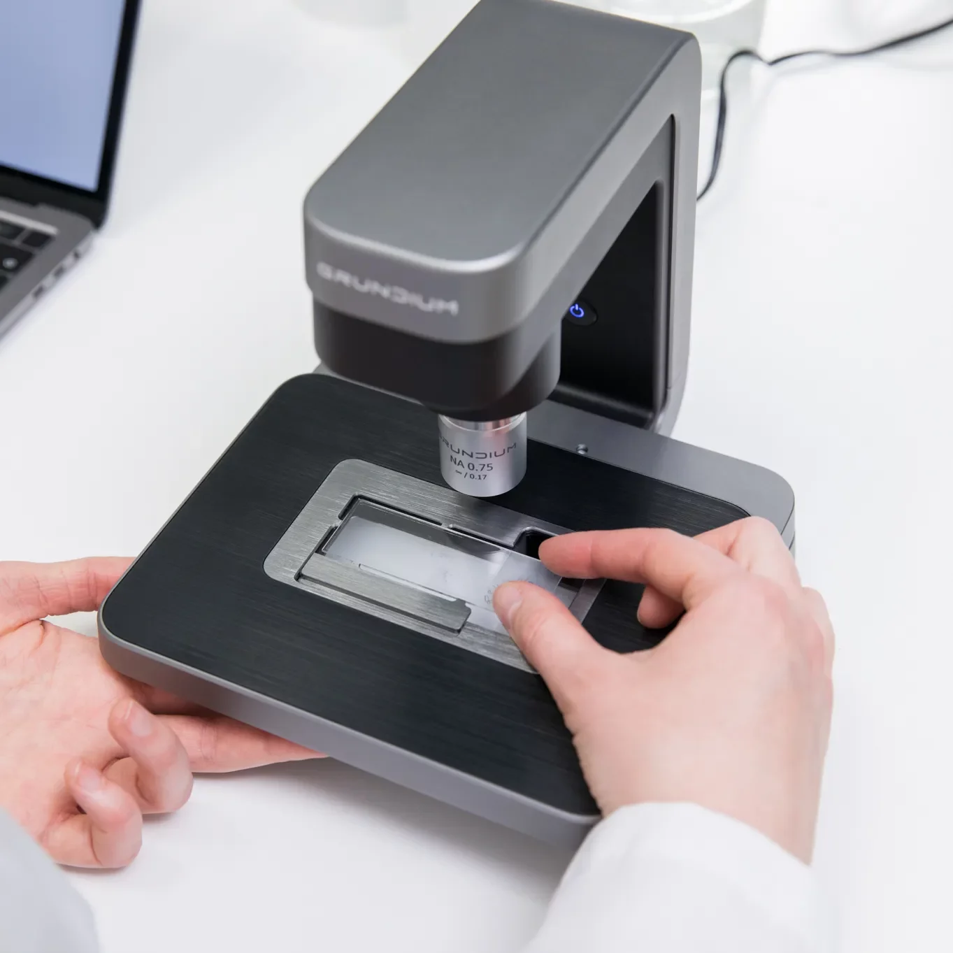 A pathologist inserting a slide into Ocus40 digital slide scanner
